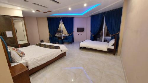 1 dormitorio con 2 camas y luz azul en City Seasons Hotel Murree en Murree