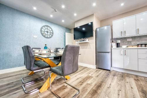 a dining room with a table and chairs and a refrigerator at Stylish House - B'ham Airport and NEC, JLR Solihull, Business & Leisure Stays - Aspen House in Solihull