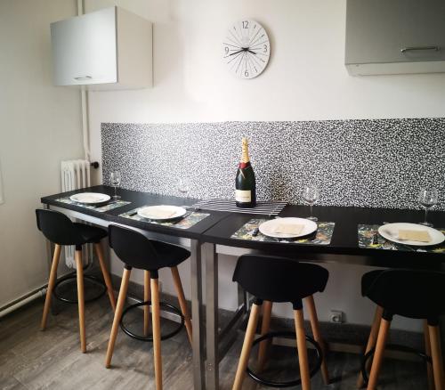 - une cuisine avec une table et des chaises ainsi qu'une bouteille de vin dans l'établissement F3 proche centre-ville - Cote Blatin, à Clermont-Ferrand
