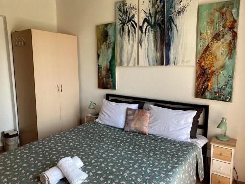 a bedroom with a bed and paintings on the wall at Artist's House in Tʼetʼri Tsqaro