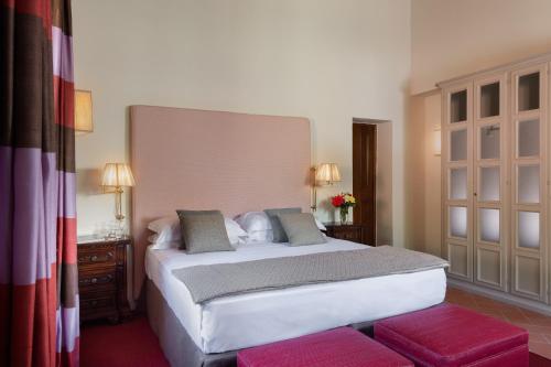 a bedroom with a large white bed in a room at Viesca Toscana Suites & Villas in Reggello