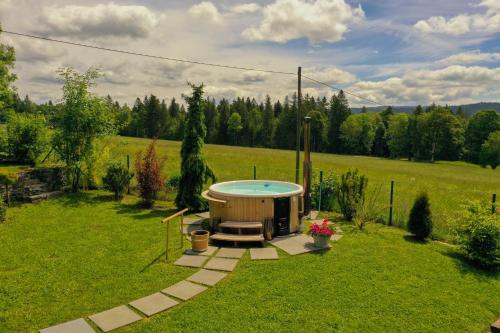 a small hot tub in the middle of a yard at Chalet en pleine nature avec Spa in Le Locle