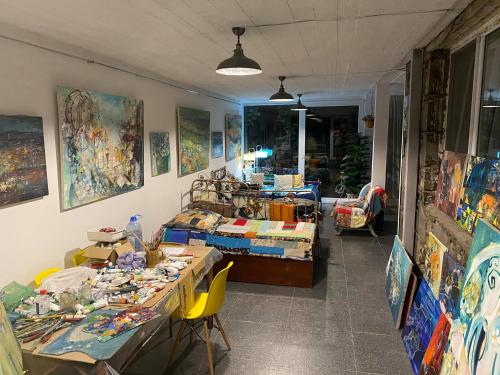 a room with a table with paintings on the walls at Artist's House in Tʼetʼri Tsqaro