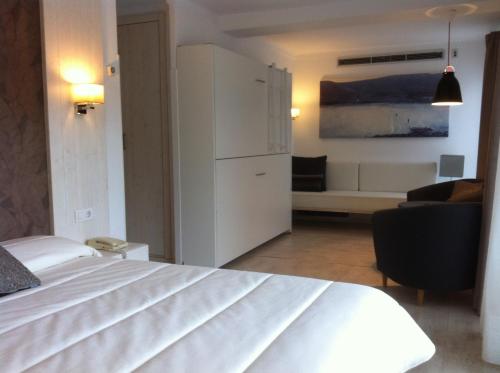 a bedroom with a white bed and a living room at Can Miquel in L'Escala