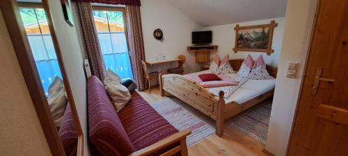 1 dormitorio con cama, sofá y TV en BioBauernhof Fresoldhof, en Schladming