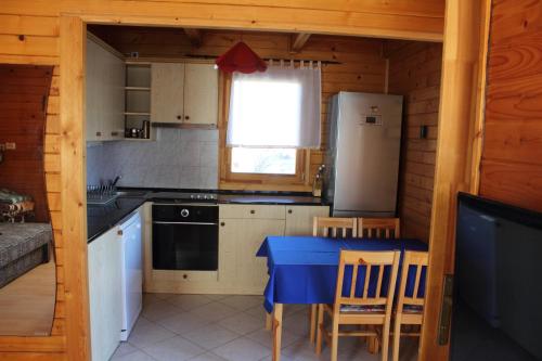 a kitchen with a blue table and a refrigerator at Sárberki Horgásztó in Lenti
