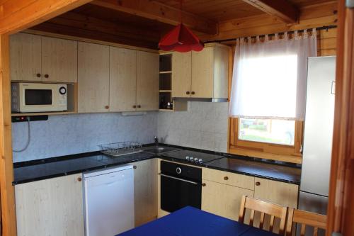 a kitchen with a stove and a microwave at Sárberki Horgásztó in Lenti