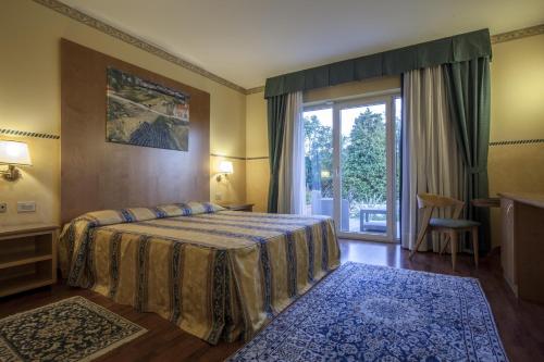 a bedroom with a bed and a large window at Hotel Al Ponte in Gradisca dʼIsonzo