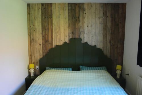 Holiday home Landelijk Amsterdam في أمستردام: غرفة نوم بسرير مع جدار خشبي