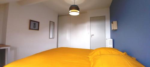 a bedroom with a bed with a yellow blanket at HISTOIRE DE LOIRE - LA TOUE in Saumur