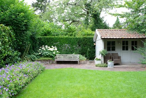 a garden with a bench and a small shed at bb-jonashome in Venlo