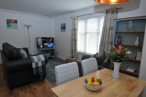 una sala de estar con una mesa con un bol de fruta. en No5 Esplanade Court, Stornoway Town Centre en Stornoway