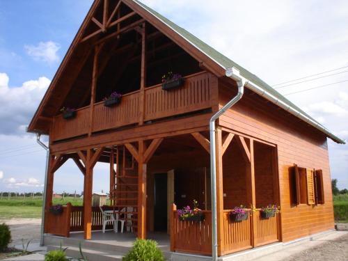 a log cabin with a porch and a balcony at Sárberki Horgásztó in Lenti
