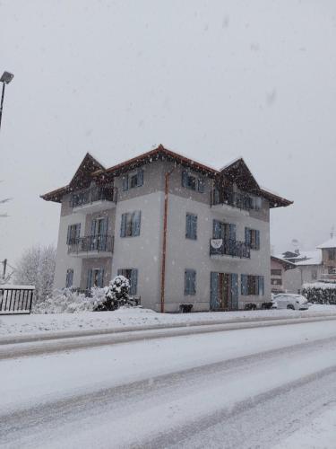 a large white building in the snow on a street at B&B ANGELA Valdinon in Predaia
