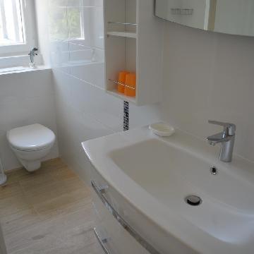 ein weißes Bad mit einem Waschbecken und einem WC in der Unterkunft Apartments Leon in Baška Voda
