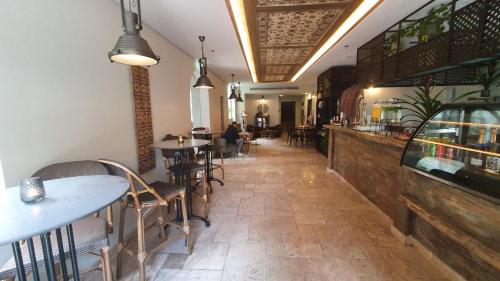 a restaurant with tables and chairs in a room at Carmella Boutique Hotel in Haifa