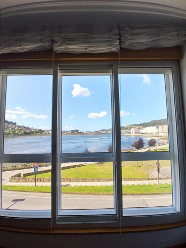 a window with a view of the water at Ría de Viveiro in Viveiro