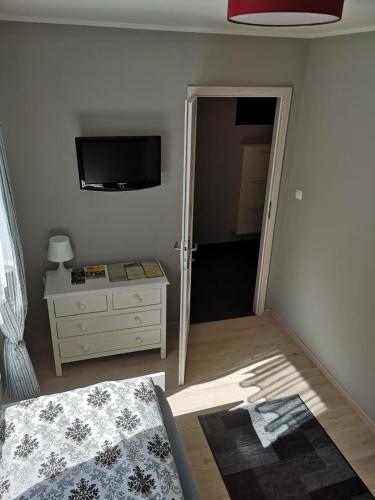 a bedroom with a bed and a dresser and a television at Apartament exclusive Głuszyca in Głuszyca