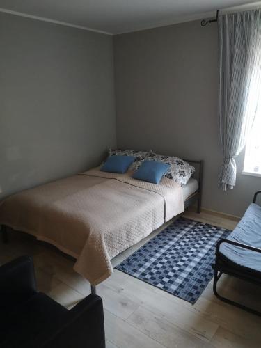 a bedroom with a bed with blue pillows and a rug at Apartament exclusive Głuszyca in Głuszyca