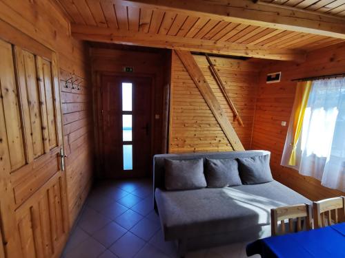 a room with a couch in a wooden room at Sárberki Horgásztó in Lenti