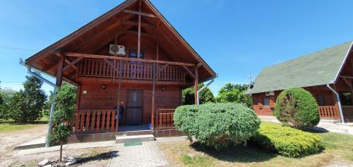 a large wooden house with a gambrel roof at Sárberki Horgásztó in Lenti