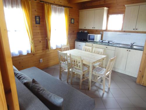 a kitchen with a table and chairs in a room at Sárberki Horgásztó in Lenti