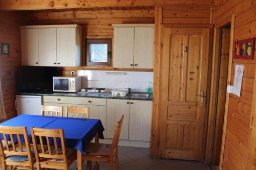 a kitchen with a table and chairs in a cabin at Sárberki Horgásztó in Lenti