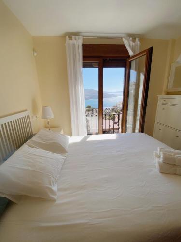 um quarto com uma grande cama branca e uma janela em Lambda LI em Almuñécar