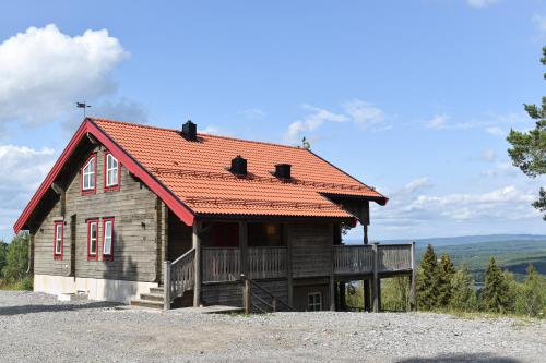 une cabane en rondins avec un toit orange dans l'établissement Alpstigen 10A - Newly built sports lodge with amazing views, à Järvsö
