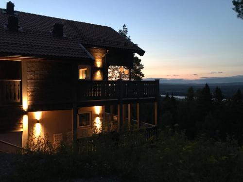 une maison avec des lumières sur l'extérieur à la tombée de la nuit dans l'établissement Alpstigen 10A - Newly built sports lodge with amazing views, à Järvsö