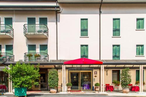 a hotel with a red umbrella in front of a building at Hotel Tegorzo in Fener