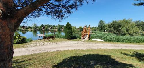 a wooden gate in a park next to a lake at Sárberki Horgásztó in Lenti