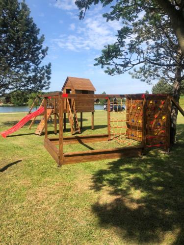 a park with a playground with a swing at Sárberki Horgásztó in Lenti