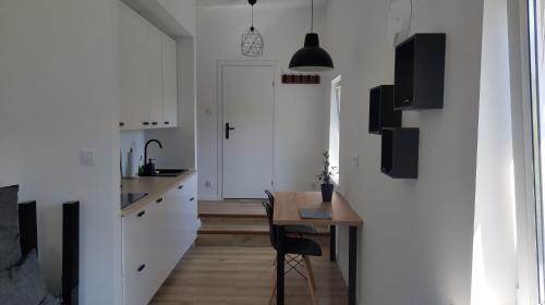 a room with a table and a kitchen with white walls at Studio 4 Piętro II in Sopot