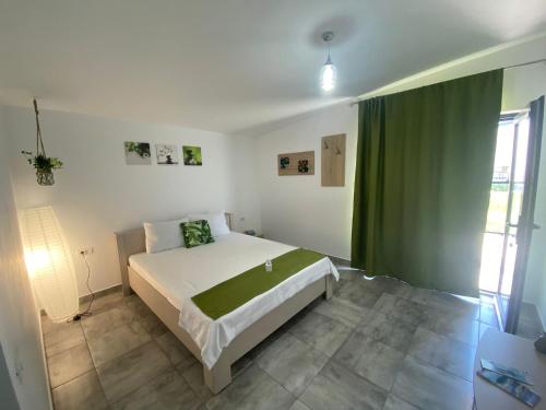 a bedroom with a large bed with a green curtain at Vara la Corbu in Corbu