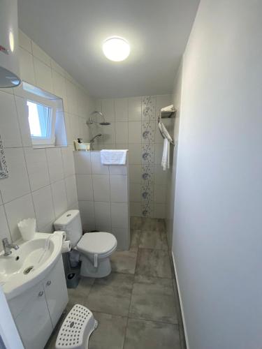 a bathroom with a white toilet and a sink at Vara la Corbu in Corbu
