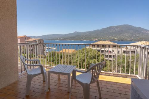 a patio with two chairs and a table on a balcony at Hotel Hibiscus in Propriano