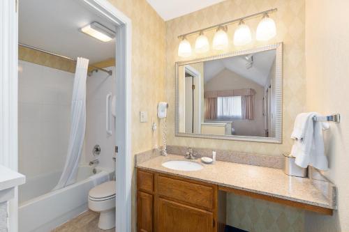 a bathroom with a sink and a toilet and a mirror at Residences at Daniel Webster in Merrimack