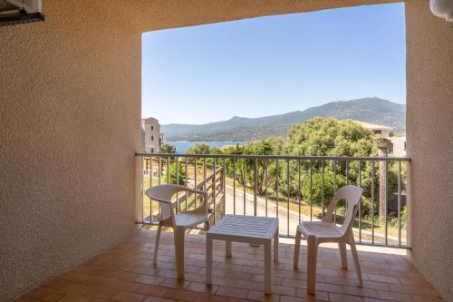 a balcony with two chairs and a table at Hotel Hibiscus in Propriano