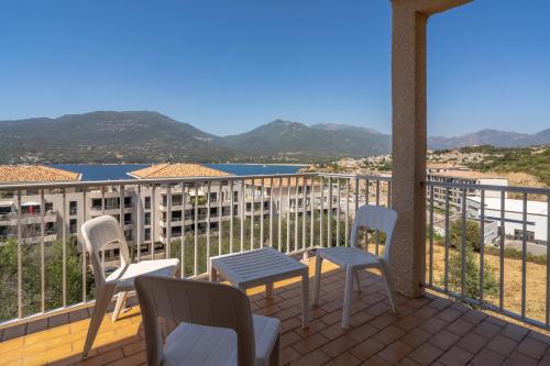 a balcony with chairs and a view of the water at Hotel Hibiscus in Propriano