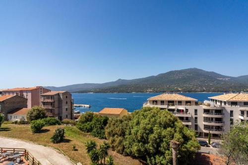 a view of a city and a body of water at Hotel Hibiscus in Propriano