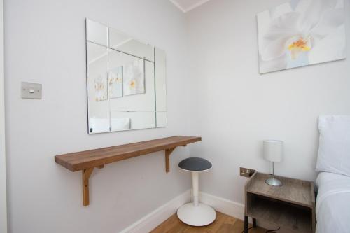 a bedroom with a mirror on the wall and a desk at Westciti Croydon Serviced Apartments in Croydon