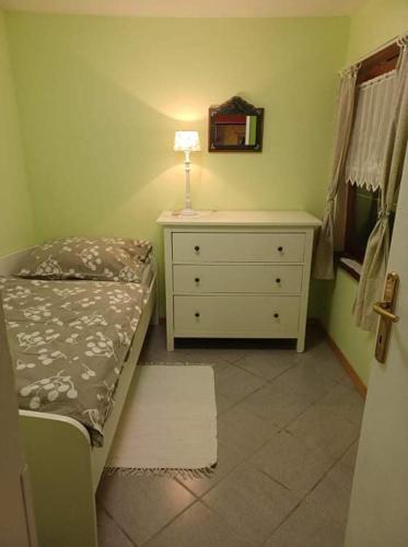 a bedroom with a bed and a dresser with a mirror at Hiška ob potoku in Dobrna