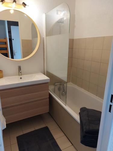 une salle de bain avec un lavabo, une baignoire et un miroir dans l'établissement Superbe Studio à 50m de la plage - Studio Koh Tao, au Lavandou