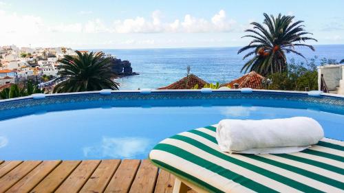 a pool with a towel sitting on a chaise lounge at Alenes del Mar in San Juan de la Rambla