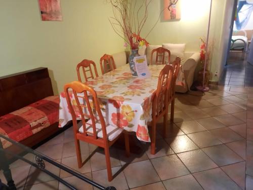 a dining room table with chairs and a table and a bed at Le Jardin de Massieux in Bouillante