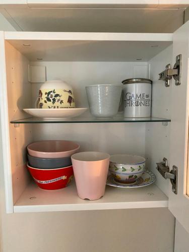 a cupboard with bowls and other dishes in it at Meublé tourisme Carmes 2 étoiles, entrée autonome,wifi, climatisé, petit parking privé in Toulouse