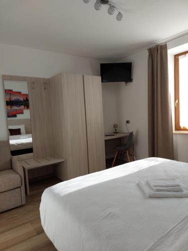 a bedroom with a bed and a couch and a television at B&B ANGELA Valdinon in Predaia