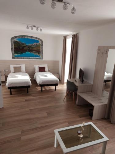a hotel room with two beds and a table at B&B ANGELA Valdinon in Predaia