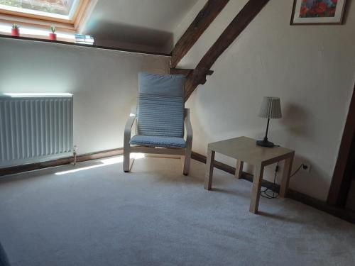 a room with a blue chair and a table at Le Moulin du Cluzeau in Chaillac
